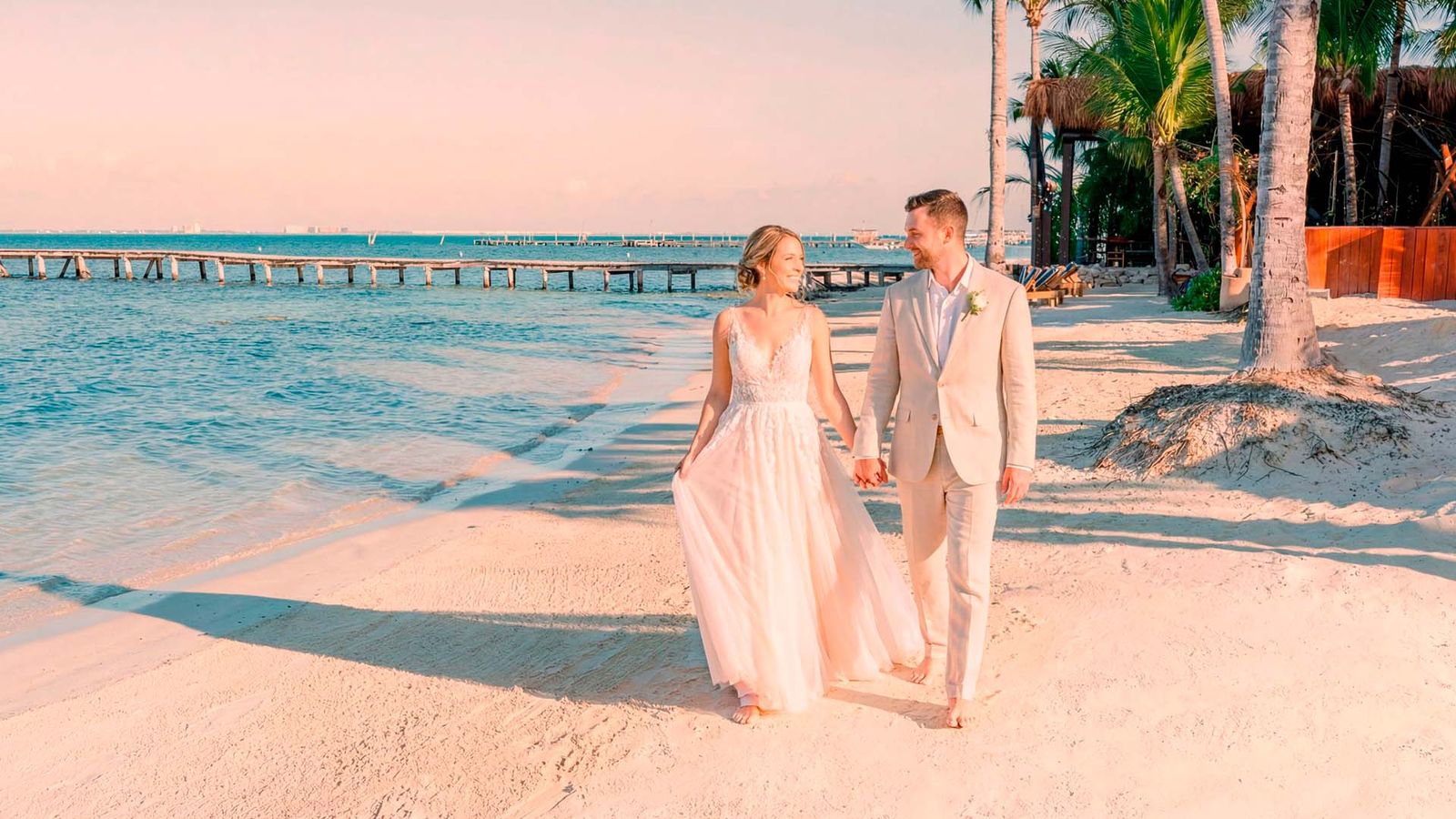 Bride and groom walking along the shore