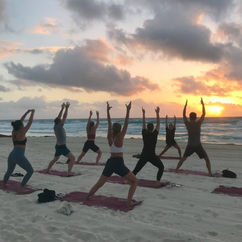 Sunset beach yoga session with Mayan Monkey guests