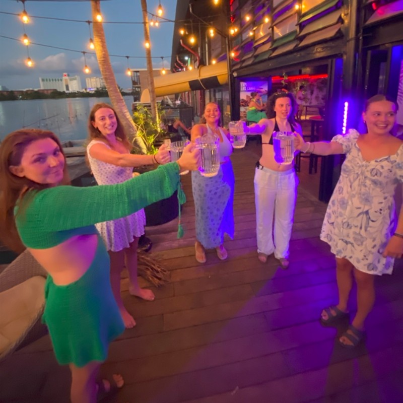 Rooftop sunset toast with beer mugs at Mayan Monkey