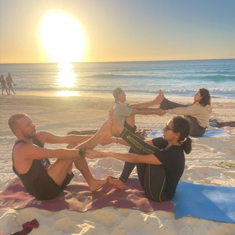 Sunrise partner yoga on the beach with Mayan Monkey guests