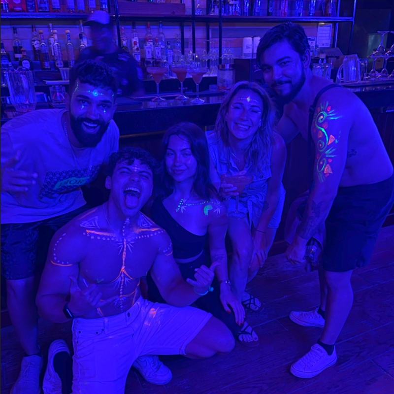 Guests with neon body paint at a blacklight party at Mayan Monkey