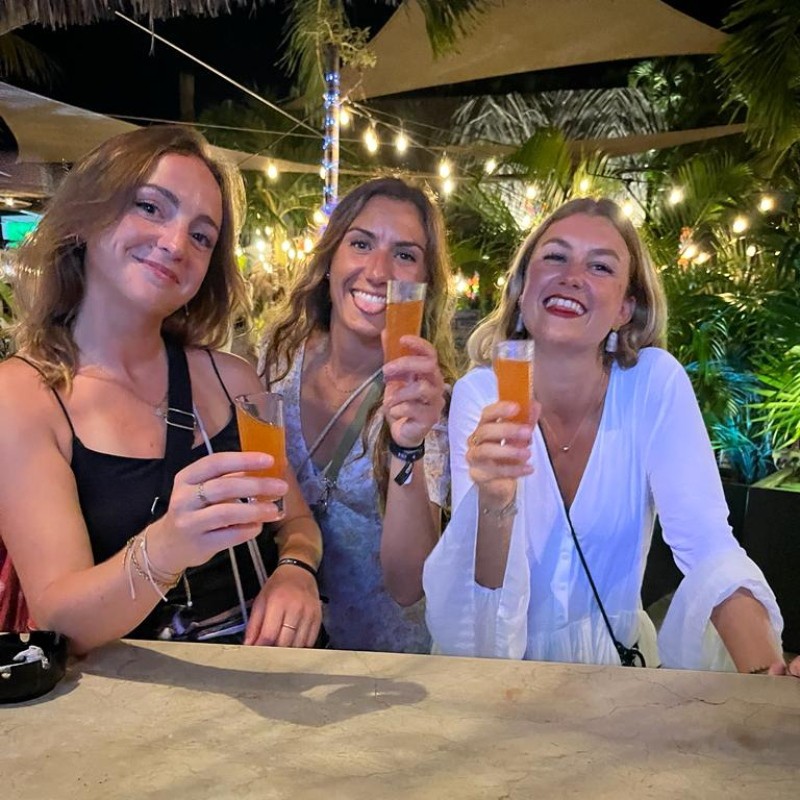 Mayan Monkey guests toasting drinks at a rooftop night party