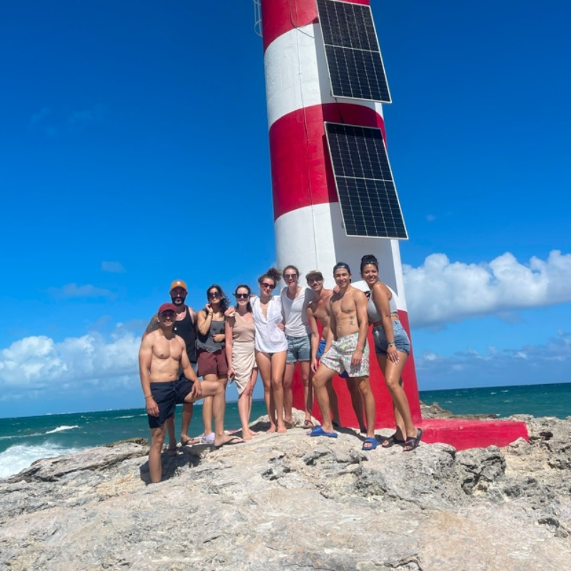 Guests posing at a lighthouse on a Mayan Monkey island excursion