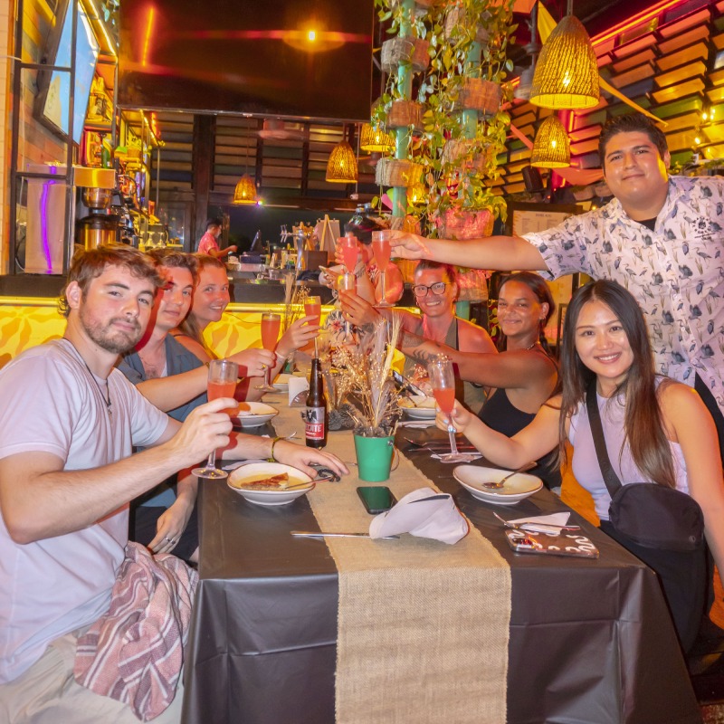 Mayan Monkey guests toasting drinks together at a rooftop dinner